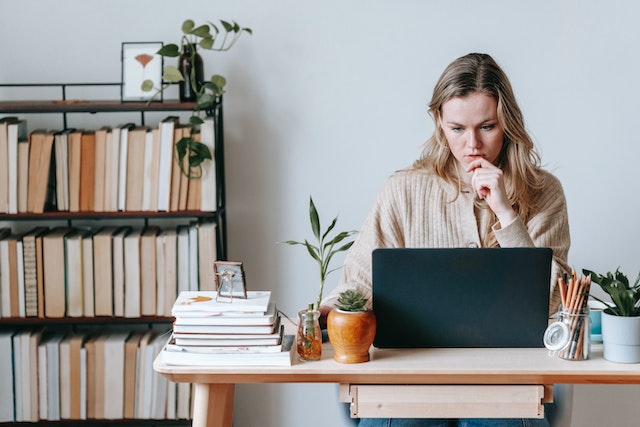 Focused person sitting at a desk working on their laptop